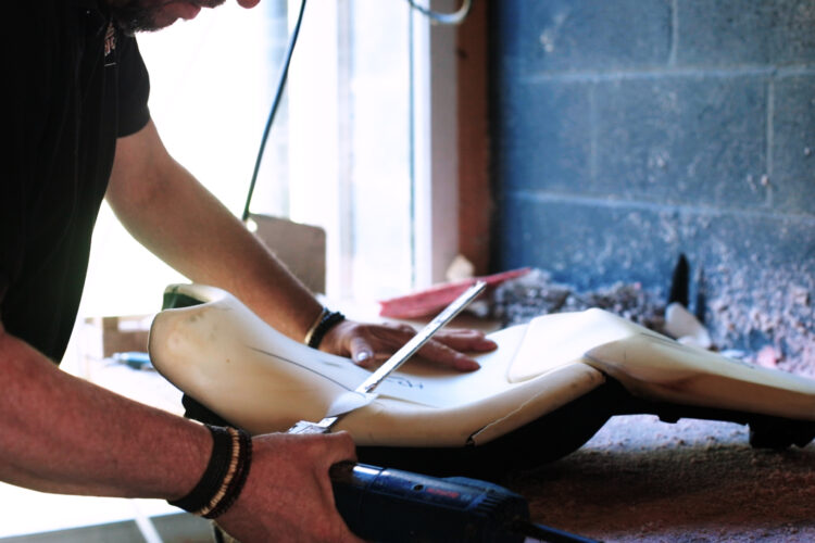 Sellier en train de refaire le mousse d'un siège